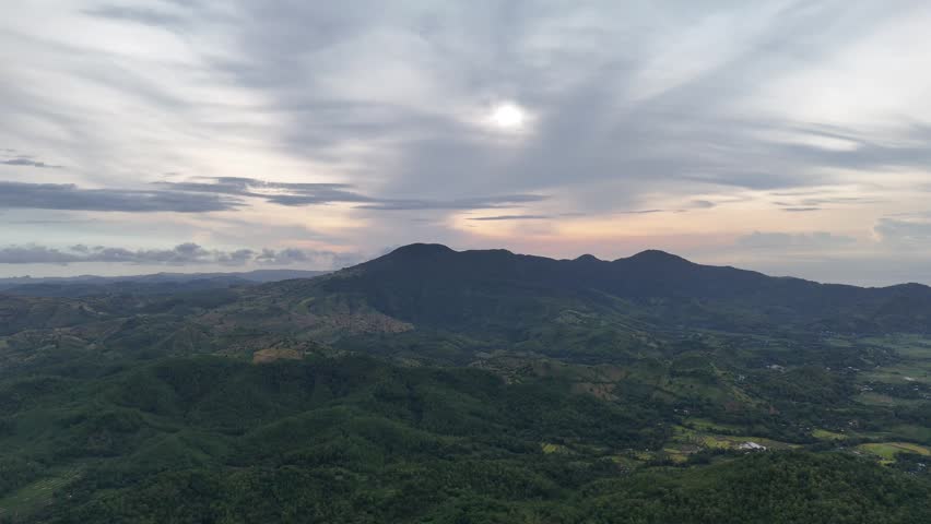 Sunrise over Lush Green Mountains and Hills with Dramatic Cloudy Sky
