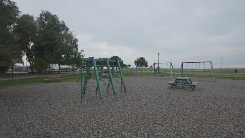 Public park playground with benches and toys in rainy weather