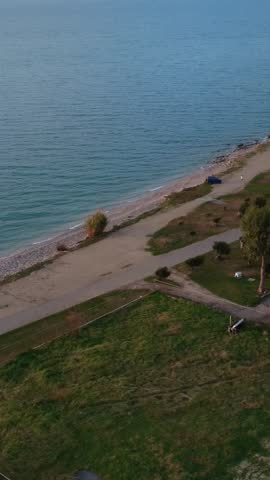 Coastal Fields and Pebble Beach with Clear Water and Dirt Path