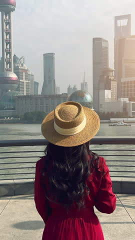 Tourists sightseeing on The Bund and Lujiazui of Shanghai, China. Vertical