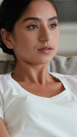Frustrated Indian Arabian woman at home couch suffering high temperature broken air conditioner sweating female feeling summer heat hormonal health problem medicine indoors stress ventilation issue