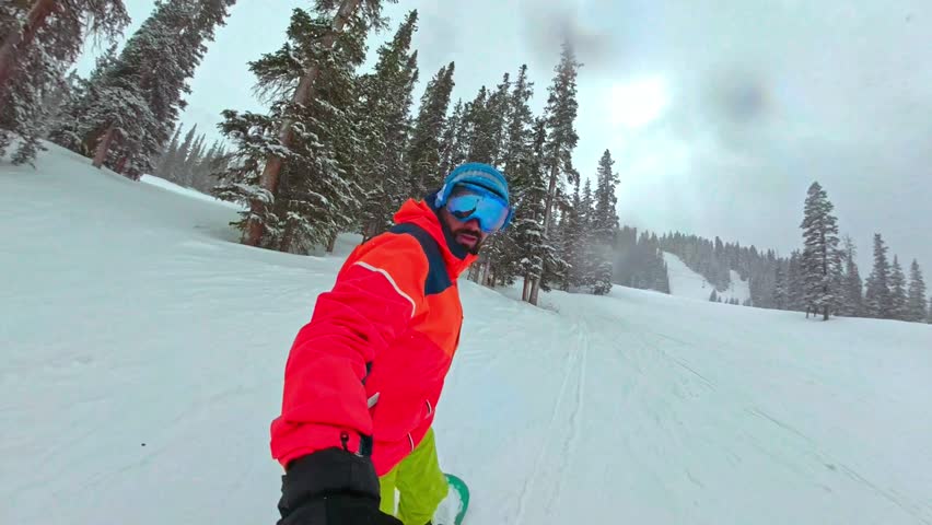 Snowboarder shredding down the slopes on a cloudy day