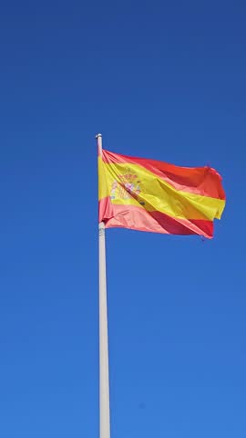 Spanish flag proudly waving, symbolizing national identity, heritage, patriotism, and european unity against a vibrant blue backdrop