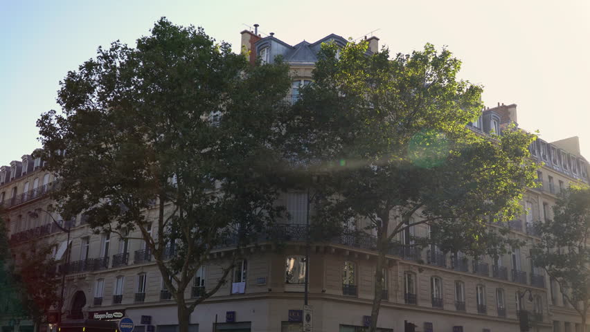 Classic Parisian architecture on the corner of Boulevard Saint Germain and Saint Michel, featuring a stone facade in the shadow during late afternoon.
