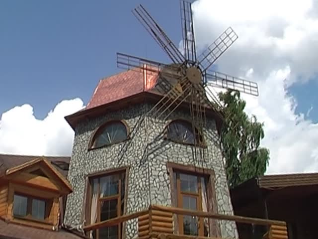 windmill against a blue sky with clouds
