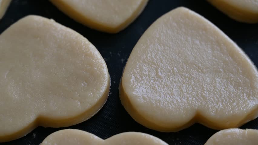 close up view of delicious heart-shaped cookies on dark surface, gingerbread cookies in shapes of stars and hearts on green background