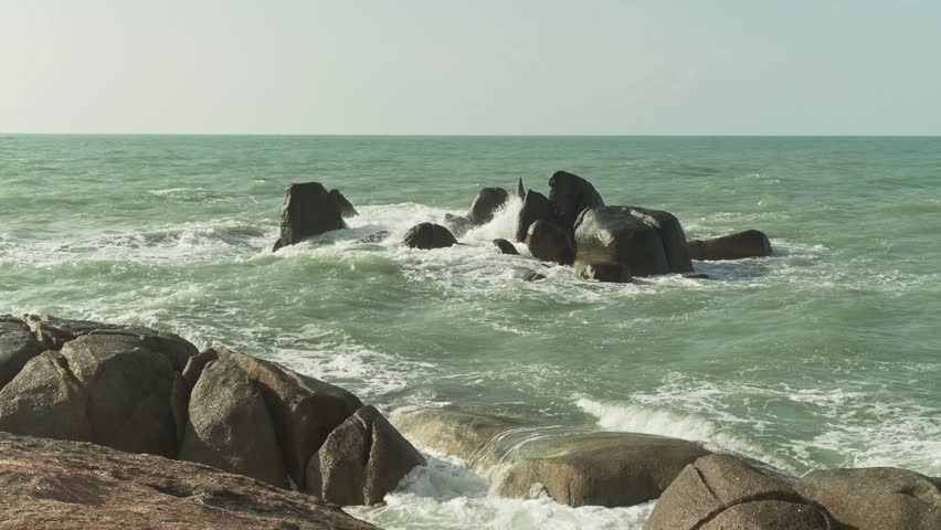 Coastal rocks with splashing water and foam.  