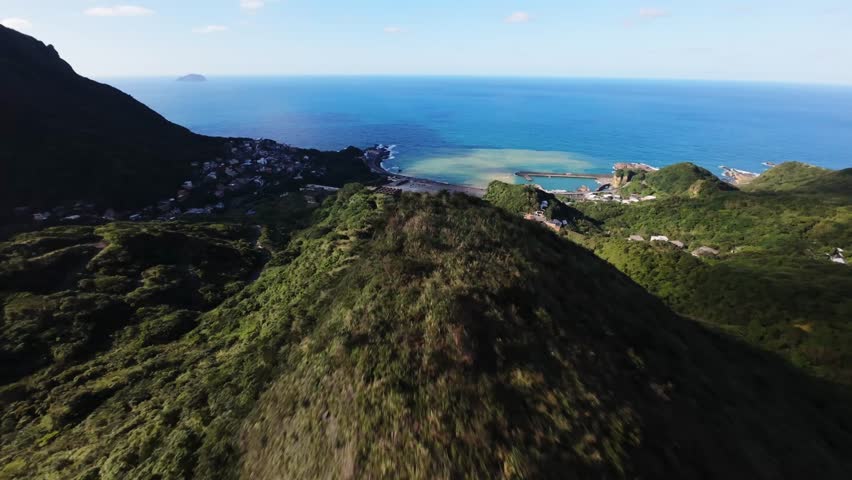 Aerial view FPV drone flies smoothly over mountains in the sea off Taiwan