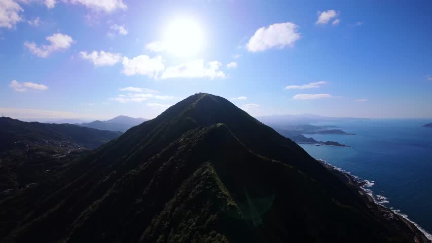 Aerial view FPV drone flies smoothly over mountains in the sea off Taiwan