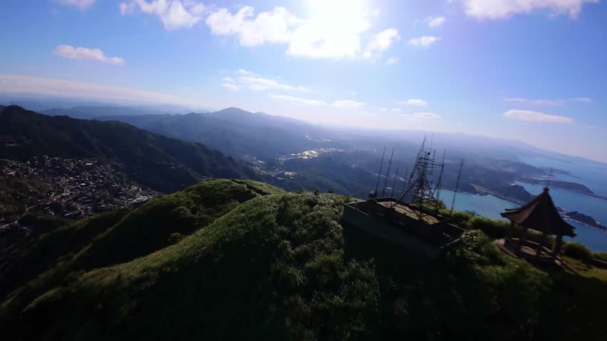 An aerial view FPV from a drone flying over majestic mountains on the island of Taiwan traversing villages and hiking trails