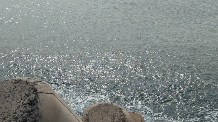 Scenic coastal video footage of sea and ocean waves at Marina Beach Chennai India with fishing boats and rocky shoreline