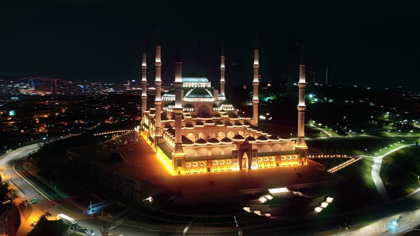 Çamlıca Mosque brilliantly illuminated at night during Ramadan, aerial hyperlapse orbiting the grand structure above Istanbul city lights