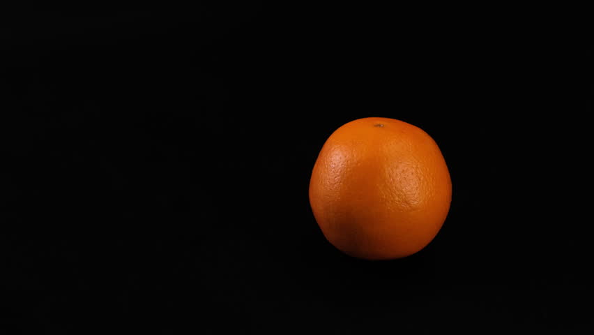 Fresh oranges in a motorized camera slider shot on a black background