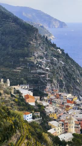 Panoramic view of Vernazza village coastline and sea in Cinque Terre Italy.
Cinematic sweeping view of Vernazza showing picturesque harbor, colorful buildings and Mediterranean sea.