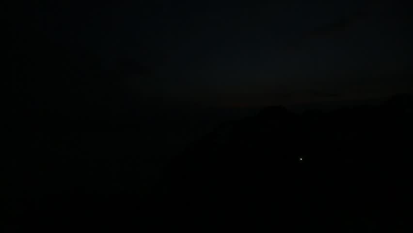 Timelapse footage of forested mountains above a sea of ​​clouds at sunrise.