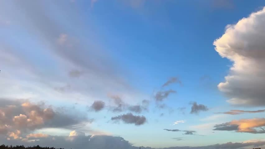 Vibrant golden sunset clouds clash with a deep blue sky, creating a dramatic, high-contrast landscape of light and shadow over a quiet horizon line.