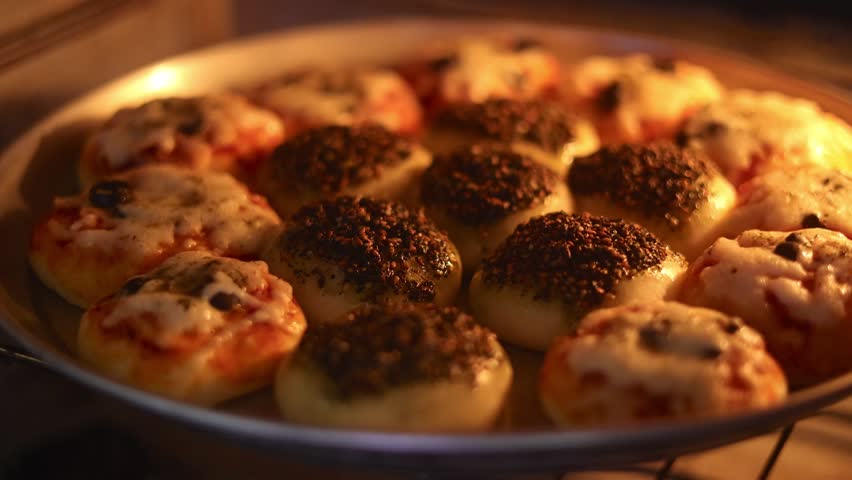Mini mixed manakish with cheese and thyme inside a hot oven, delicious Lebanese style pastries.