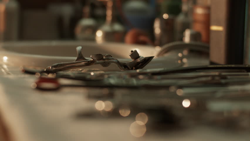 Vintage metal barber tools placed on polished sink surface