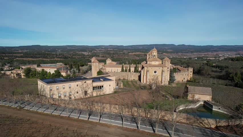 Tilt down aerial shot of Santa Maria de Poblet Monastery on sunny winter day. Tarragona Province, Spain.