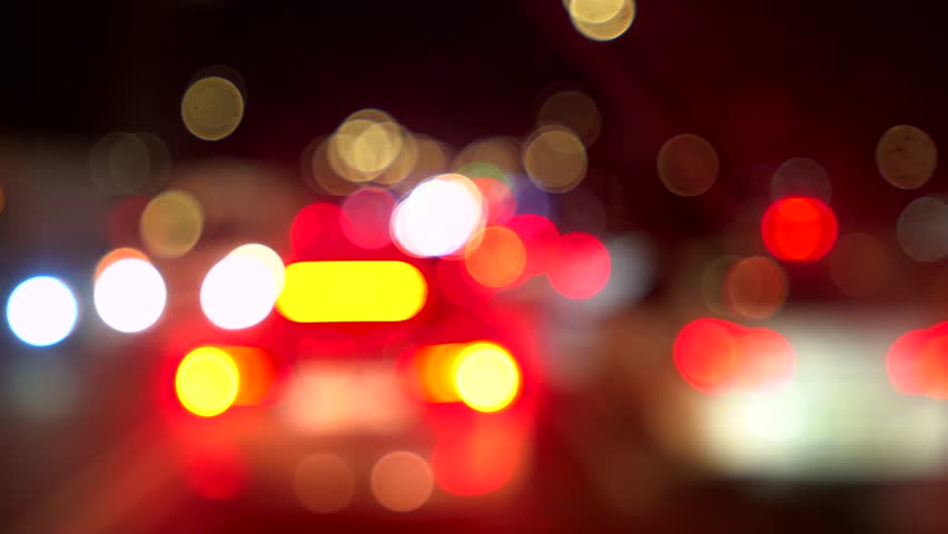 Video with multicolored bokeh lights of night city car traffic. Blurred cinematic footage of night time street with glowing round lights. Red white and yellow bokeh circles of cars moving creating abstract background perfect for music overlays transitions or intros