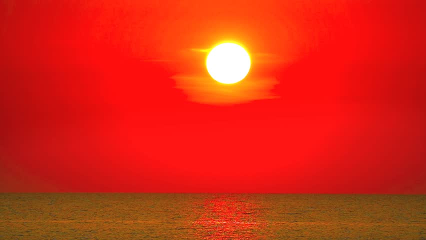 Dark Red Sky Over Sea at Sunset with Clear Clouds and Omega Sun During Time Lapse Photography