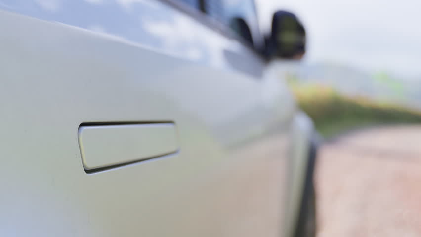 Close-up view of a modern electric vehicle's flush door handle automatically extending, showcasing innovative automotive technology and the aerodynamic design of a luxury battery-powered car