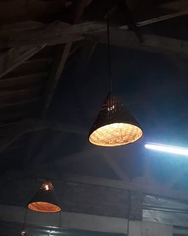 Traditional bamboo wicker pendant lamps glowing in a dark room