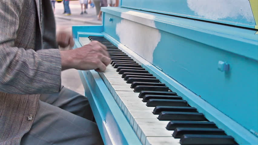 Older gentleman plays Jazz piano on a public street .