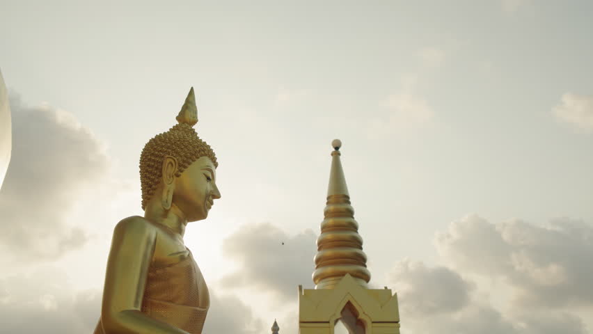 Golden Buddha statue silhouette with sun backlight at Big Buddha temple Koh Samui.