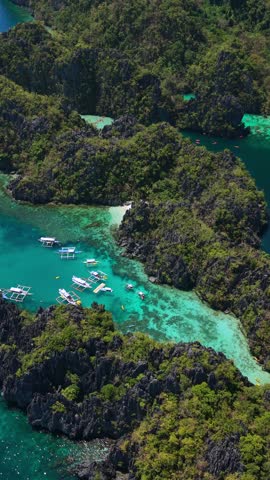 Aerial drone view of Small Lagoon in El Nido, Palawan, Philippines, with turquoise water, limestone cliffs, and traditional boats in famous tropical paradise.