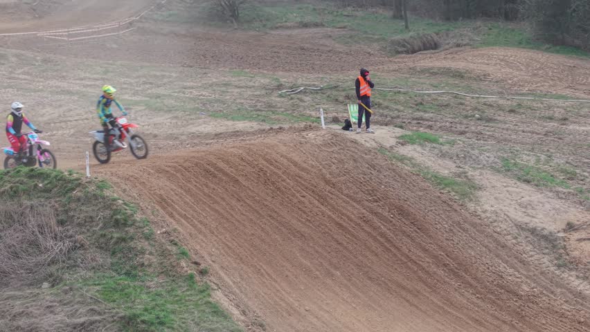 Aerial drone footage of motocross cross country race, dirt bikes speeding on rugged track, riders competing in off-road extreme motorsport event, dynamic action and dust clouds Poland, Głogów, 04.28.2026