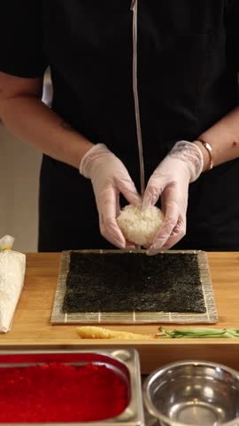 at a Japanese restaurant. The chef is making sushi rolls