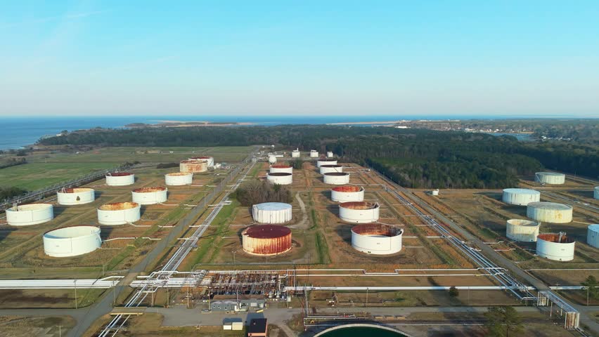 Aerial wide-angle view of the Yorktown Power Station fuel storage terminal featuring industrial oil tanks and infrastructure along the Virginia coast at sunset.