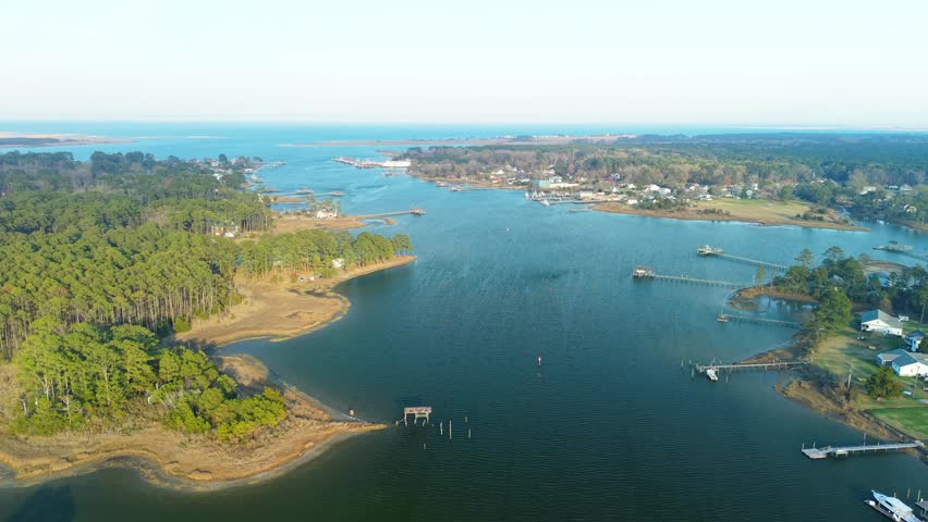 Aerial video of the York River coastline in Yorktown, Virginia, featuring lush green forests, residential docks, and calm blue water stretching toward the horizon.