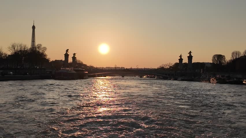 Wide view of Eiffel Tower and Seine river during sunset with soft evening light in Paris