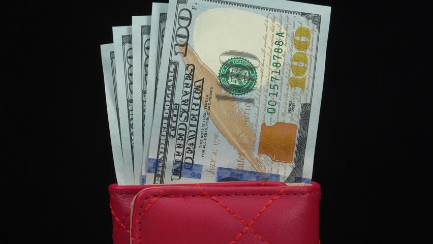American dollars in wallet. 500 dollars banknotes in red wallet. Cash, finance, savings, wealth. New hundred dollar bills in red leather wallet. Five new blue 100 dollar bills