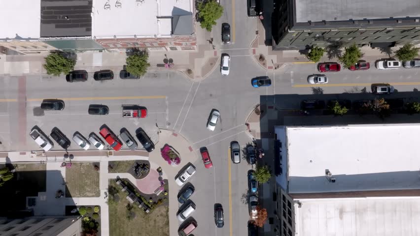 Downtown intersection with traffic in Kokomo, Indiana with drone video overhead.