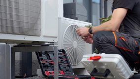 Technician servicing outdoor heat pump unit with tools beside residential house. Concept of HVAC maintenance, home climate control and energy efficient heating and cooling - Powered by Shutterstock - Get 15% off with code: PIKWIZARD15