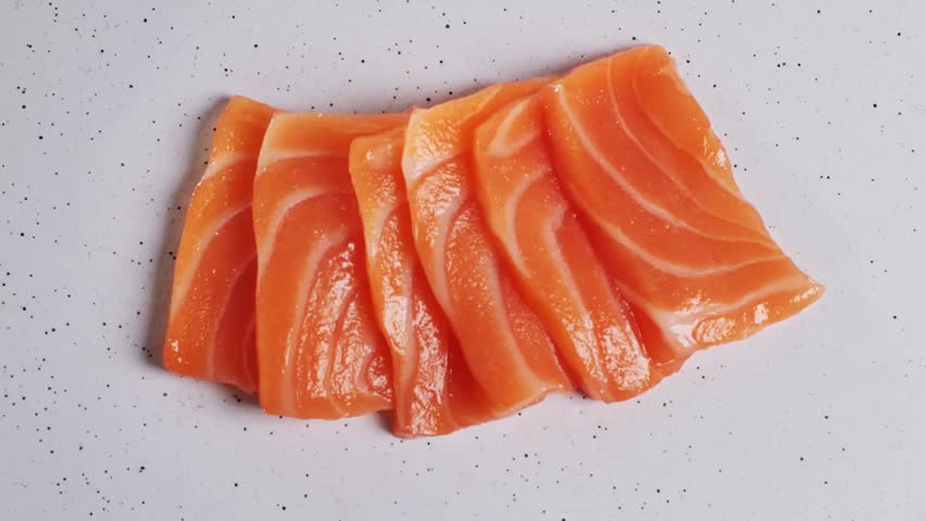 Fresh sashimi platter with tuna and salmon slices served in a modern Japanese restaurant, showcasing traditional cuisine and vibrant colors.