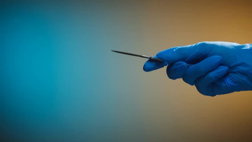 Doctor in protective glove holding scalpel closeup, surgical instrument ready for operation, healthcare, medical procedure and sterile environment concept.