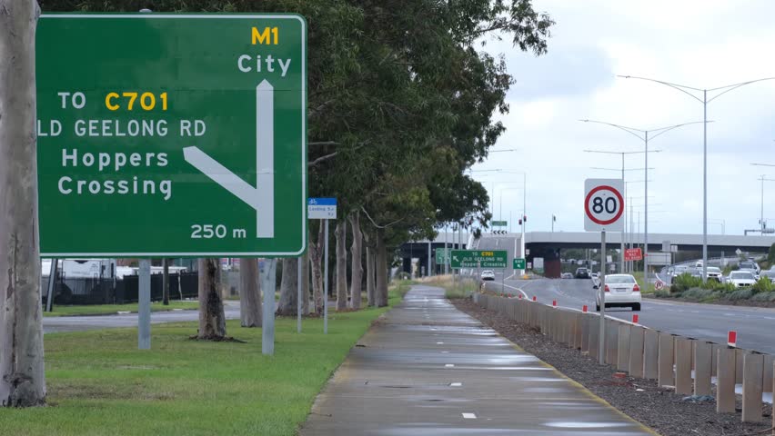 Directional road sign to M1 City and Old Geelong Road toward Hoppers Crossing in Melbourne, Australia. Navigation systems, transport infrastructure and commuting routes