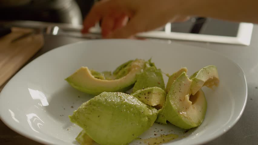 Fresh avocado pieces are seasoned with salt, pepper, and oil, then mashed together to create a flavorful guacamole perfect for dipping or spreading.
