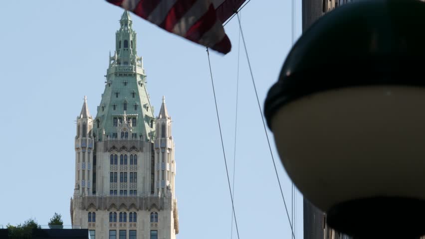 New York City Woolworth building 1913, skyscraper on Broadway in Downtown Financial District, Lower Manhattan, United States of America. Gothic historic architecture, cooper roof, USA american flag.