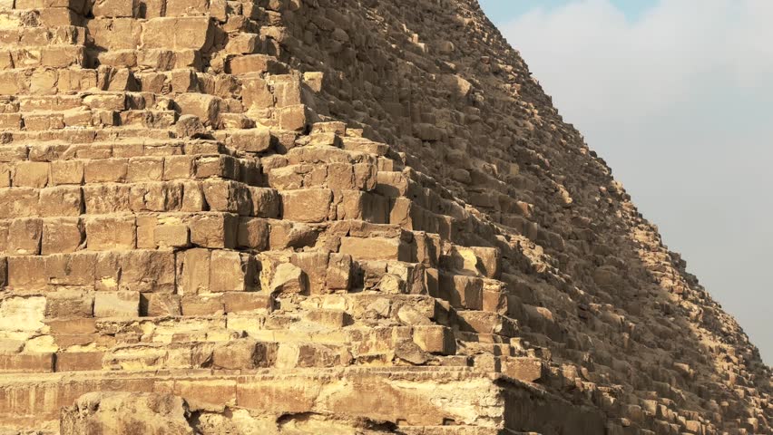 Stone blocks on the angle of Pyramid of Khafre apex with original limestone casing remnants. Tilt up detailed cinematic motion shot