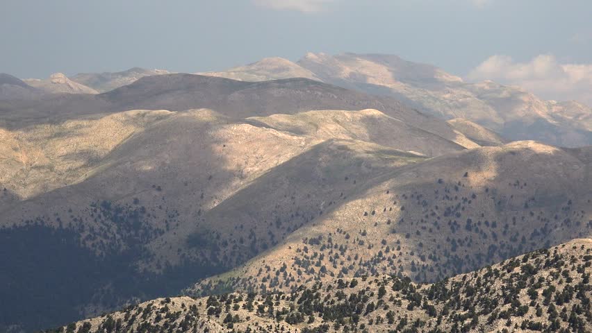 Time-lapse of Mexico’s vast mountain ranges with deep valleys and scattered trees under open sky. The Sierra Madre Oriental, Sierra Madre Occidental, and Sierra de California form rugged landscapes. Layered relief, exposed strata, broken slopes, distant ridgelines give strong geographic structure across the entire view. Rock, soil, scrub, forest cover, open meadow patterns emphasize landform contrast shaped by climate, long erosion. Elevation change becomes especially clear where valleys, plateaus, cliffs, basins, high ridges organize visual rhythm across frame. Regional character feels convincing thanks to genuine topography, broad horizons, unforced relationships between surface texture, contour. Wide framing preserves spatial clarity, while motion direction keeps depth readable from foreground texture toward distant forms. Steady observation supports documentary realism, because composition stays clean, legible, easy to interpret during continuous movement. Panoramic sweep or fixed perspective provides usable establishing material for travel, geography, environment, atmospheric storytelling. Scale relationships remain strong, since vantage, horizon placement, gradual transitions reveal authentic proportions across terrain. Foreground detail anchors scale, middle distance builds depth, remote horizon completes convincing spatial continuity. Natural color variation separates primary forms, secondary textures, background layers without artificial stylization. Ambient mood remains consistent, giving footage polished yet realistic observational character. Visual hierarchy stays coherent, allowing eye movement across major subjects, supporting details, distant context. Lighting preserves tonal nuance, edge definition, material contrast instead of exaggerated treatment. Textural richness rewards slow viewing, because surfaces, silhouettes, motion cues remain easy to study.