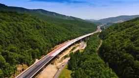 Long freeway is being built along the spectacular mountains. Drone footage above the road construction. - Powered by Shutterstock - Get 15% off with code: PIKWIZARD15