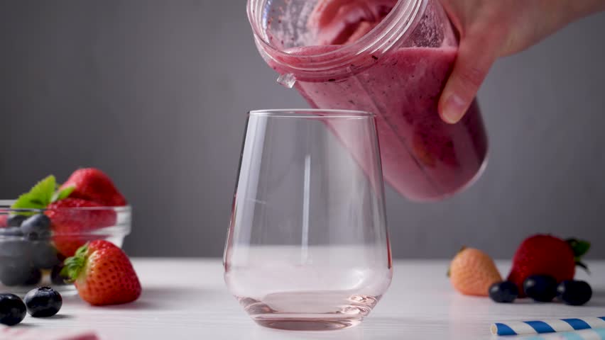 Pouring berry smoothie made from fresh fruits and berries, healthy eating 