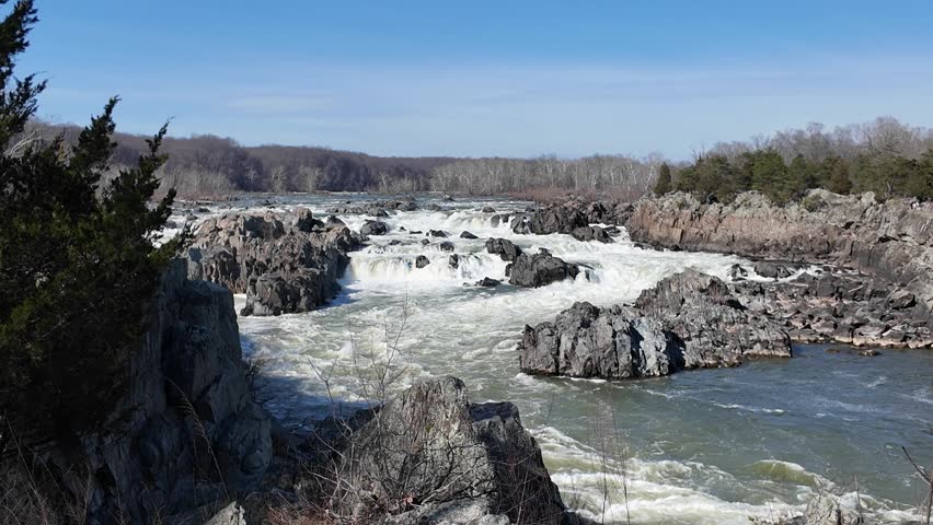 Powerful river rapids flowing through a rocky landscape on a clear day
