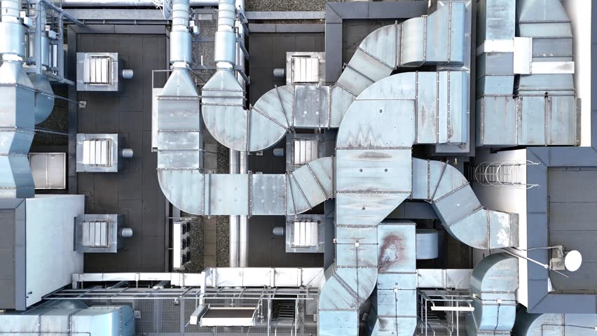 Aerial view of industrial rooftop showcasing extensive HVAC system with interconnected ducts, vents, and units demonstrating complex engineering and design in a modern facility layout