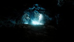 A stunning blue ice cave covered with snow, illuminated by glowing light, showcasing icy textures, frozen formations, and a surreal winter landscape atmosphere. - Powered by Shutterstock - Get 15% off with code: PIKWIZARD15